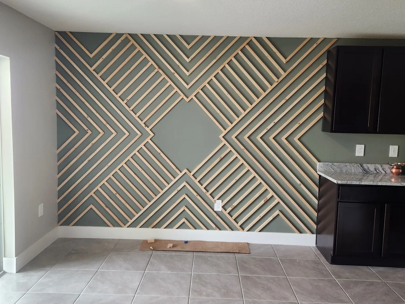 Geometric wood accent wall installed in a finished room